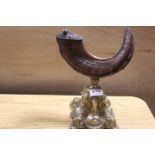 A VINTAGE TABLE SNUFF IN THE FORM OF A RAMS HORN ON ORNATE METAL BASE