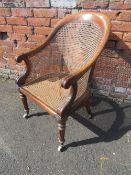 A REGENCY ROSEWOOD BERGERE ARMCHAIR ON CASTORS