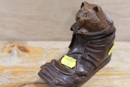 A VINTAGE WOODEN INKWELL IN THE FORM OF A CAT PEEPING OUT OF A SHOE