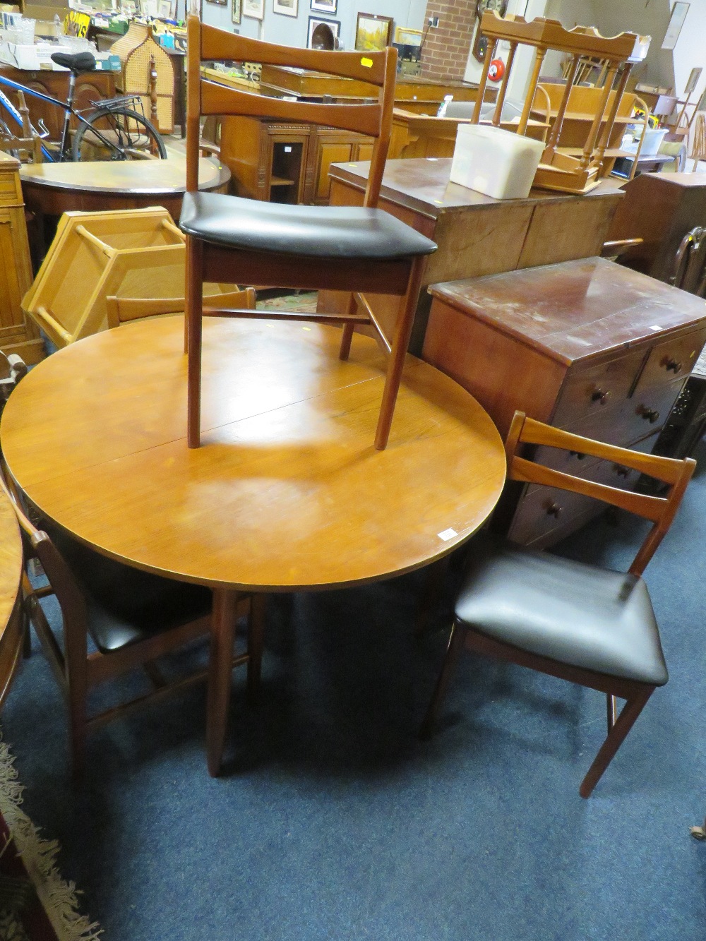 A VINTAGE TEAK EXTENDING DINING TABLE AND FOUR CHAIRS