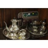 TWO SILVER PLATED TRAYS WITH VARIOUS TEAPOTS, COFFEE POTS, MILK JUGS ETC