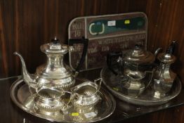 TWO SILVER PLATED TRAYS WITH VARIOUS TEAPOTS, COFFEE POTS, MILK JUGS ETC