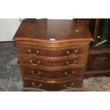 A REPRODUCTION SERPENTINE CHEST OF FOUR DRAWERS WITH BRUSHING SLIDE - A/F