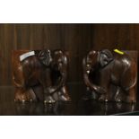 A PAIR OF CARVED WOODEN BOOK ENDS IN THE FORM OF ELEPHANTS