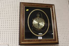 A FRAMED AND GLAZED WALL CLOCK IN THE FORM OF A POCKET WATCH