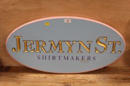 A VINTAGE OVAL WOODEN ADVERTISING SIGN FOR 'JERMYN STREET SHIRT MAKERS'