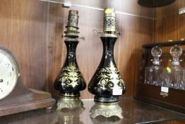 A PAIR OF FRENCH GILT METAL MOUNTED BLACK CERAMIC OIL LAMPS