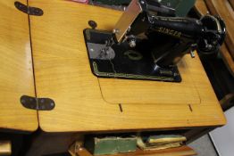 A VINTAGE OAK SINGER SEWING MACHINE DESK AND CONTENTS SERIAL NUMBER K8709280 PLUS ACCESSORIES
