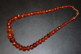 AN AMBER FACETED BEAD NECKLACE