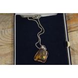 A SILVER MOUNTED AMBER NECKLACE