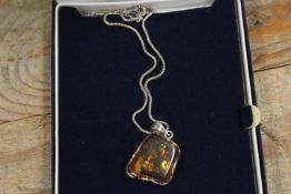 A SILVER MOUNTED AMBER NECKLACE