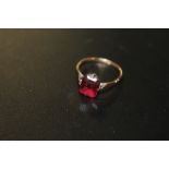 A 9CT ROSE GOLD DRESS RING SET WITH A RED STONE APPROX 1.9G