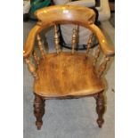 AN ANTIQUE SMOKERS BOW ARMCHAIR