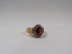 A VINTAGE 18CT GOLD LADIES GEMSET DRESS RING, the central oval faceted red stone surrounded by small