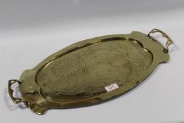 AN ARTS AND CRAFTS OVAL BRASS TRAY, with engraved floral details, twin handles, W 57.5 cm