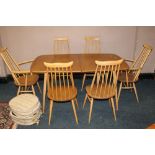 A BLOND ERCOL DRAWLEAF DINING TABLE WITH SIX STICKBACK CHAIRS, having two spare leaves