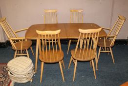 A BLOND ERCOL DRAWLEAF DINING TABLE WITH SIX STICKBACK CHAIRS, having two spare leaves