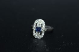 AN ART DECO STYLE SAPPHIRE AND DIAMOND RING, set with a central Princess cut blue sapphire and