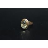 A HALLMARKED 9 CARAT GOLD DRESS RING, set with a pale olive green quartz style oval stone