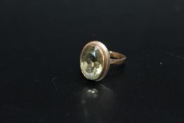 A HALLMARKED 9 CARAT GOLD DRESS RING, set with a pale olive green quartz style oval stone
