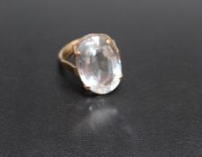 A 9CT GOLD DRESS RING, set with a large polished clear quartz style stone, approx 22 mm by 14 mm,