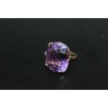 A VERY LARGE AMETHYST RING, the cushion cut style stone measures an approx 24 mm by 21 mm and is set