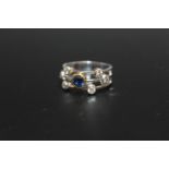 A HANDMADE 18 CARAT WHITE GOLD SAPPHIRE AND DIAMOND SPLIT BAND RING, set with a single sapphire of