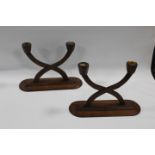 A PAIR OF EARLY 20TH CENTURY MAHOGANY SECESSIONIST STYLE TWIN BRANCH CANDLESTICKS, raised on oval