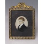 A 19TH CENTURY OVAL PORTRAIT MINIATURE OF A YOUNG MAN, in a black jacket and white stock,