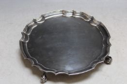 A HALLMARKED SILVER SALVER BY B.S.LTD - BIRMINGHAM 1972, with piecrust border and raised on four