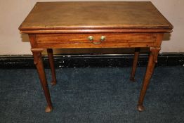 AN EARLY 19TH CENTURY RED WALNUT FOLD-OVER TEA TABLE, in the Irish style, raised on circular tapered