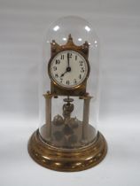 AN EARLY 20TH CENTURY BRASS CASED TORSION CLOCK, with three ball carriage under plastic dome, H 30