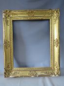 A 19TH CENTURY DECORATIVE GOLD SWEPT FRAME - SOME DAMAGES, frame W 14 cm, rebate 76 x 60 cm