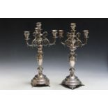 A PAIR OF UNMARKED WHITE METAL CANDLESTICKS, having central twin handled urn design central column