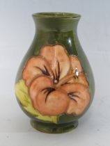 A SMALL MOORCROFT POTTERY HIBISCUS PATTERN BUD VASE, evidence of paper label to base, H 9.5 cm