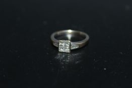 A SIX STONE DIAMOND RING, having four Princess cut diamonds set in a square in a rub over setting