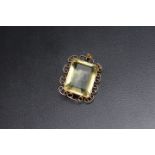 A LARGE GREEN / YELLOW RECTANGULAR PENDANT, possibly tourmaline? set in unmarked yellow metal,