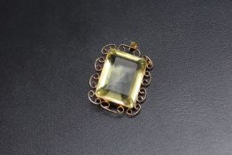 A LARGE GREEN / YELLOW RECTANGULAR PENDANT, possibly tourmaline? set in unmarked yellow metal,