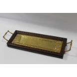 AN UNUSUAL OAK FRAMED ARTS AND CRAFTS BRASS RECTANGULAR TRAY, having twin handles, the tray with