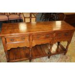 A 20TH CENTURY OAK THREE DRAWER DRESSER, raised on turned supports, with undertier, H 89 cm, W 166