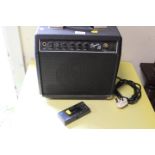A SMALL SQUIRE 15 AMPLIFIER TOGETHER WITH A HOHNER QUARTZ DIGITAL GUITAR TUNER
