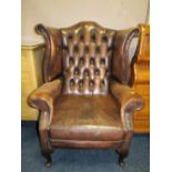 A VINTAGE BROWN LEATHER WINGBACK ARMCHAIR
