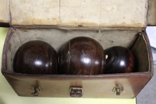 AN ANTIQUE LEATHER CASED SET OF WOODEN TURNED LAWN BOWLS COMPLETE WITH JACK BY THOMAS TAYLOR OF