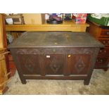 AN ANTIQUE CARVED OAK PANELLED COFFER