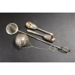 A SILVER DIFFUSER STAMPED STERLING, TWO UNUSUAL PIERCED SCOOPS STAMPED STERLING, AND A CANDLE