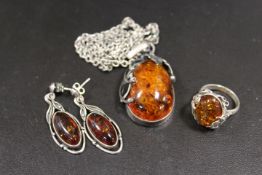 AN AMBER PENDANT OF SILVER CHAIN TOGETHER WITH A RING AND EARRINGS