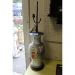 AN ORIENTAL PATTERNED PORCELAIN LAMP BASE ON WOODEN STAND, WITH BRASS AND COPPER FITTINGS