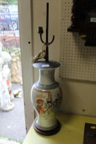 AN ORIENTAL PATTERNED PORCELAIN LAMP BASE ON WOODEN STAND, WITH BRASS AND COPPER FITTINGS