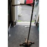 A CAST IRON BASED STAND WITH LION PAW FEET