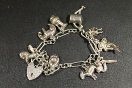 A SILVER CHARM BRACELET AND CHARMS